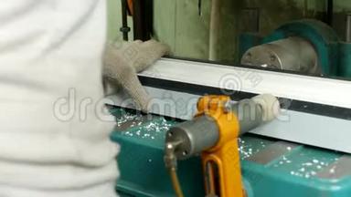 生产和制造<strong>PVC</strong>窗户，一名女工在机器上安装<strong>PVC</strong>型材，并钻一个洞。